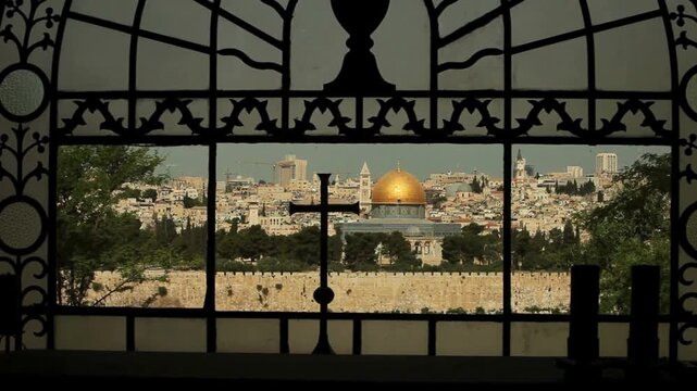 View of the dome of the rock in jerusalem through a window with a cross