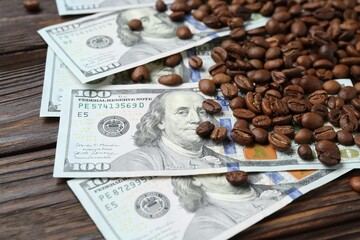 Roasted coffee beans and dollar banknotes on wooden table, closeup