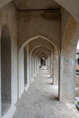A long hallway with arched windows and a stone wall
