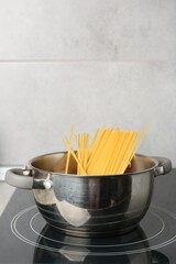 Fresh tagliatelle pasta boiling in pot on electric stove