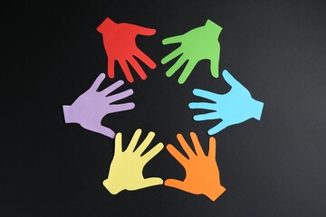 Tolerance concept. Colorful paper hands on black background, flat lay