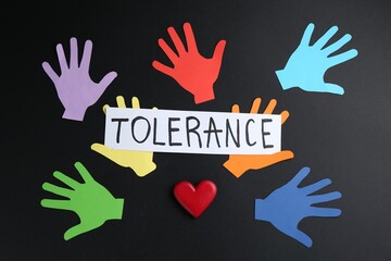 Card with word Tolerance and colorful paper hands on black background, flat lay