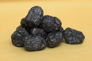 Dried ajwa dates (Khajoor) on a khaki background are food for breaking the fast during the Islamic...
