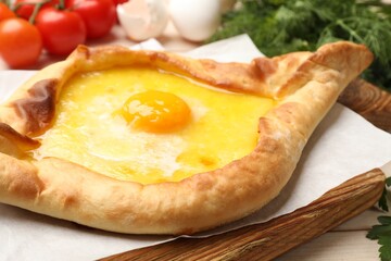 Tasty khachapuri with cheese and egg served on table, closeup