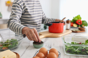 Senior woman cooking at white marble table in kitchen, closeup