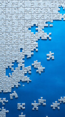 White jigsaw puzzle pieces scattered across a vibrant blue background with some pieces connected graphic