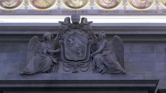 Marble relief sculpture of two angels holding papal coat of arms in Basilica of Saint Paul Outside the Walls, Rome