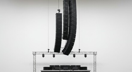 Suspended Pro Audio Power - Black Line Array Speakers Hanging in a Minimalist White Space.