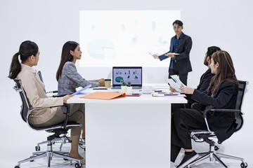 Focused corporate team attending strategy meeting with projector and charts, highlighting leadership, innovation, and teamwork in professional workplace setting.