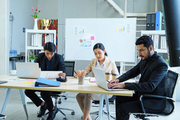 Professional colleagues collaborating on project strategy at meeting table with digital devices and files, highlighting innovation, communication, and corporate success.