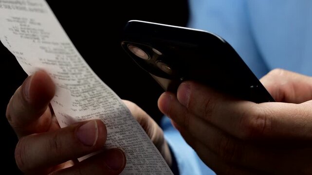 Banker with phone and paper check in hands.
Paper bill in hands of businessman after online shopping.
Scanning receipt after shopping.
Shopping, online, buy, transaction