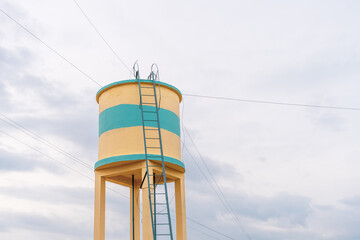 A tall water tower with a ladder on it