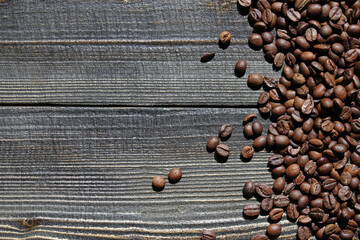 Close-up of roasted coffee beans scattered on a wooden surface