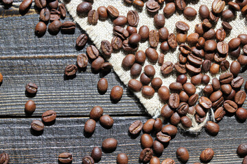 Close-up of roasted coffee beans scattered on a wooden surface