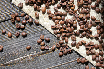 Close-up of roasted coffee beans scattered on a wooden surface
