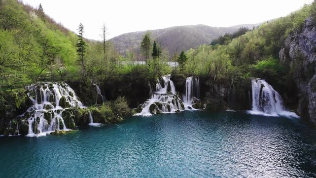 A close-up aerial view of the powerful waterfalls of the Krka River in Croatia.. Water crashes through lush greenery creating a dynamic natural scene.