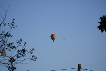 Hot air balloon is floating in the sky above a blue sky