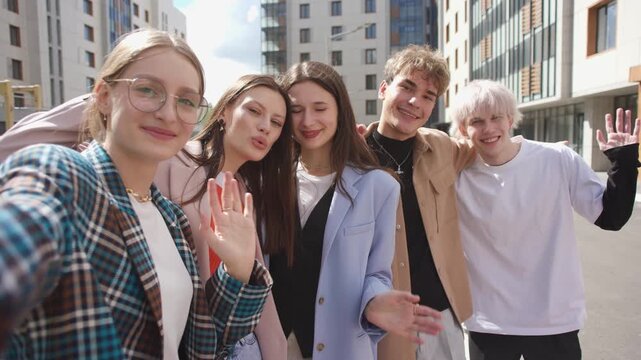 A group of happy people is sharing a fun moment. Young friends take a selfie picture during a leisure event. The team is traveling together. Smiling community portrait looking at camera