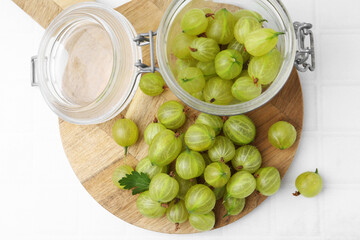 Fresh green gooseberries on white tiled table, top view