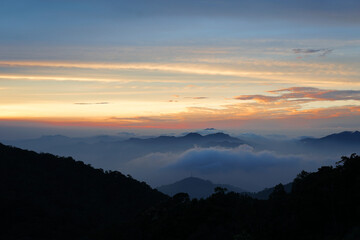 Serene Mountain Landscape with Colorful Sunrise and Misty Clouds