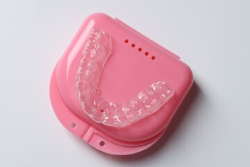 One clear aligner and retainer case on light grey background, top view