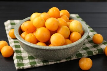 Ripe yellow cherry plums on black wooden table, closeup