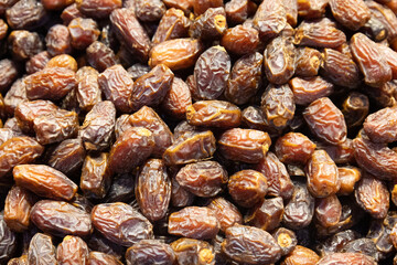 Fresh organic dried dates stacked in a traditional market stall close up