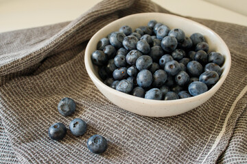 Fresh blueberries in the bowl on the kitchen table close up