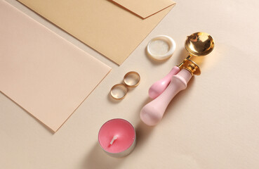 Wedding invitation stationery set. Envelope with sealing wax, vintage stamps and gold rings on...