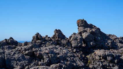 Jagged volcanic rock formations under a clear blue sky