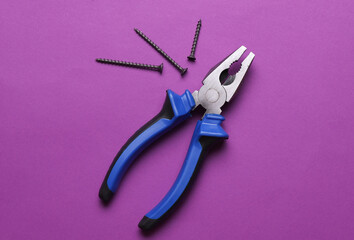 Pliers with screws on a purple background