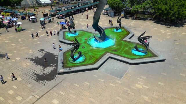 A cinematic drone shot revealing the famous Quetzalcoatl Fountain in Plaza Tapatia, Guadalajara, Mexico