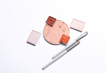 Crushed eyeshadow for makeup and brushes. Cosmetic product sample on white background. Creative...