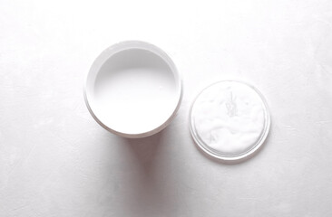 Open can of white paint on concrete background. Top view