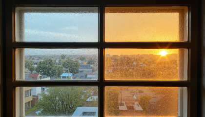 Fototapeta premium Window with condensation inside and dry dust outside at sunset with Half clear, half orange