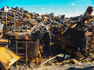 The aftermath of a vehicle fire reveals a scene of devastation, with charred remains and twisted...