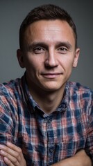 IT specialist in a casual shirt smiling confidently during a professional portrait session indoors