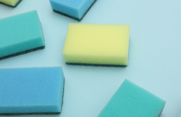 Set of colored cleaning sponges on a blue background