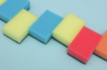 Set of colored cleaning sponges on a blue background
