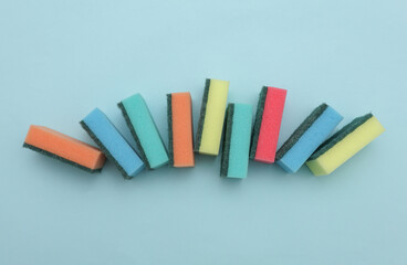 Set of colored cleaning sponges on a blue background