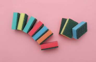 Set of colored cleaning sponges on a pink background