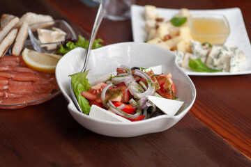 Restaurant dishes on the table. Caesar salad, cheese and salmon