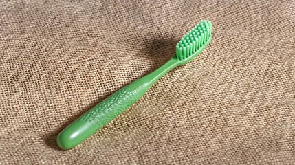 Green Toothbrush on Burlap Background Closeup Photography