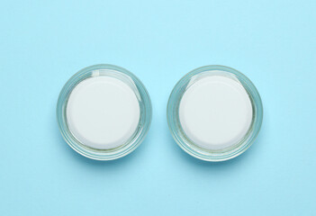 Jars of cream on a blue background. Top view. Mockup, template for design