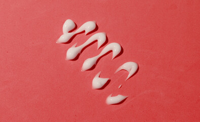 Smear of cream on red background