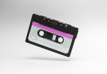 Fototapeta premium Retro audio cassette levitating on white background. Minimalism