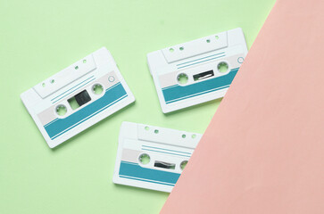 Fototapeta premium Retro 80s audio cassettes on blue pink background. Music concept, vintage technology. Top view