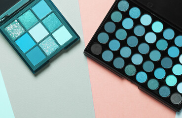 Makeup palettes on a colored background. Top view