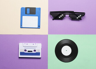 Audio cassettes, pixel glasses and floppy disks on a colored background. Creative layout, retro 80s, top view, conceptual pop