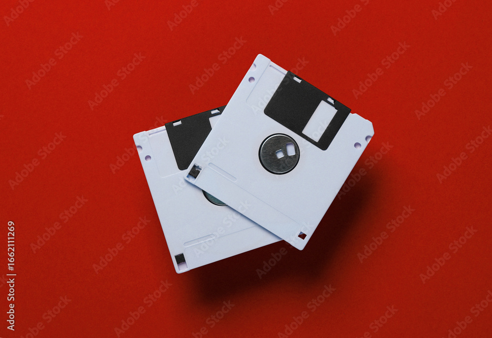 Poster white floppy disks on a red background. retro technology. top view